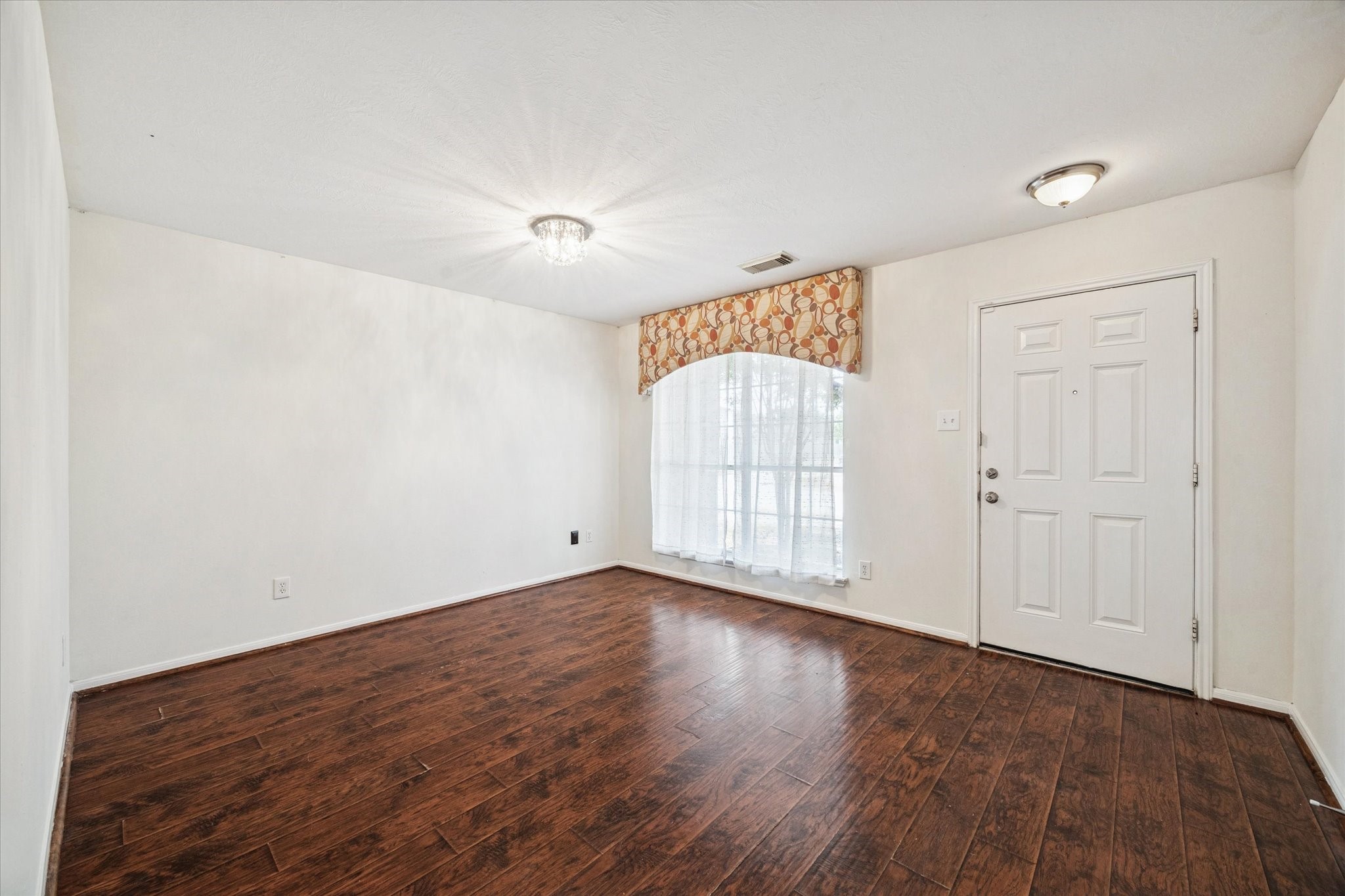 14102 Kinsbourne Lane Houston, TX 77014 - Photo 2 of 13 The front room has a large, picture window with upholstered valance, vinyl plank flooring, and sparkling chandelier. Great space for a formal dining set, den, or office.