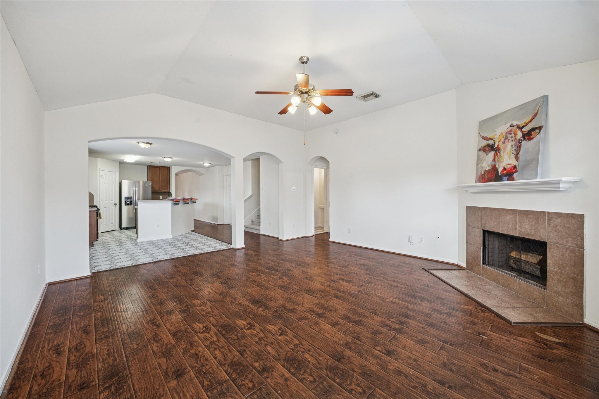14102 Kinsbourne Lane Houston, TX 77014 - Photo 4 of 13 The spacious den has a high, vaulted ceiling, ceiling fan with lights, and wood burning fireplace. Vinyl plank flooring continues from the front door through the den to the backdoor. Powder room with a pedestal sink sits off the den and has the same vinyl tile that is in the kitchen and breakfast area.