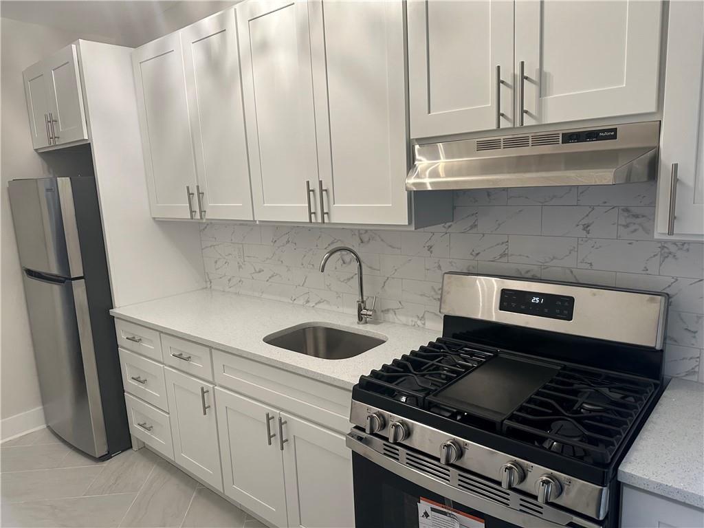 2227 83rd Street Brooklyn, NY 11214 - Photo 24 of 28 a kitchen with granite countertop a sink stove and refrigerator