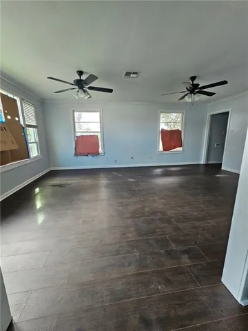 an empty room with windows and fireplace