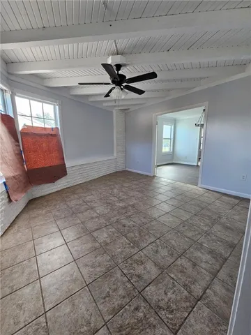 a view of a livingroom with a chandelier fan and windows