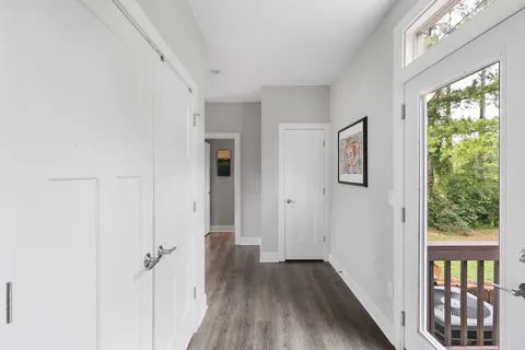 a view of a hallway with wooden floor and windows