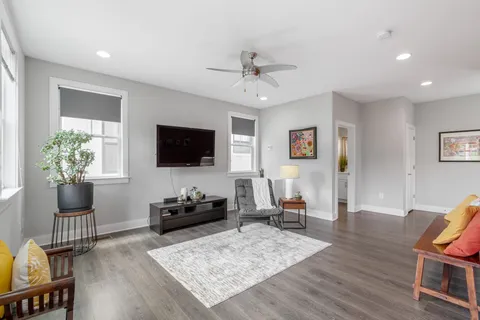a living room with furniture a flat screen tv and a potted plant