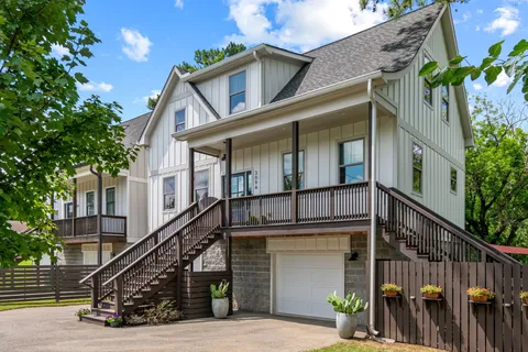a view of a house with wooden stairs and a small yard