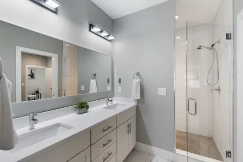 a bathroom with a double vanity sink shower and mirror