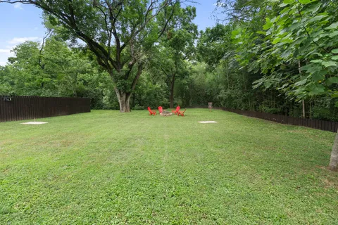 a backyard of a house with plants and large trees