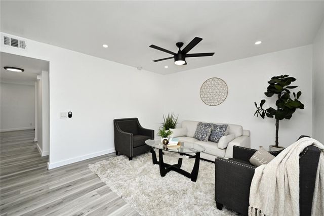 a living room with furniture a window and a clock