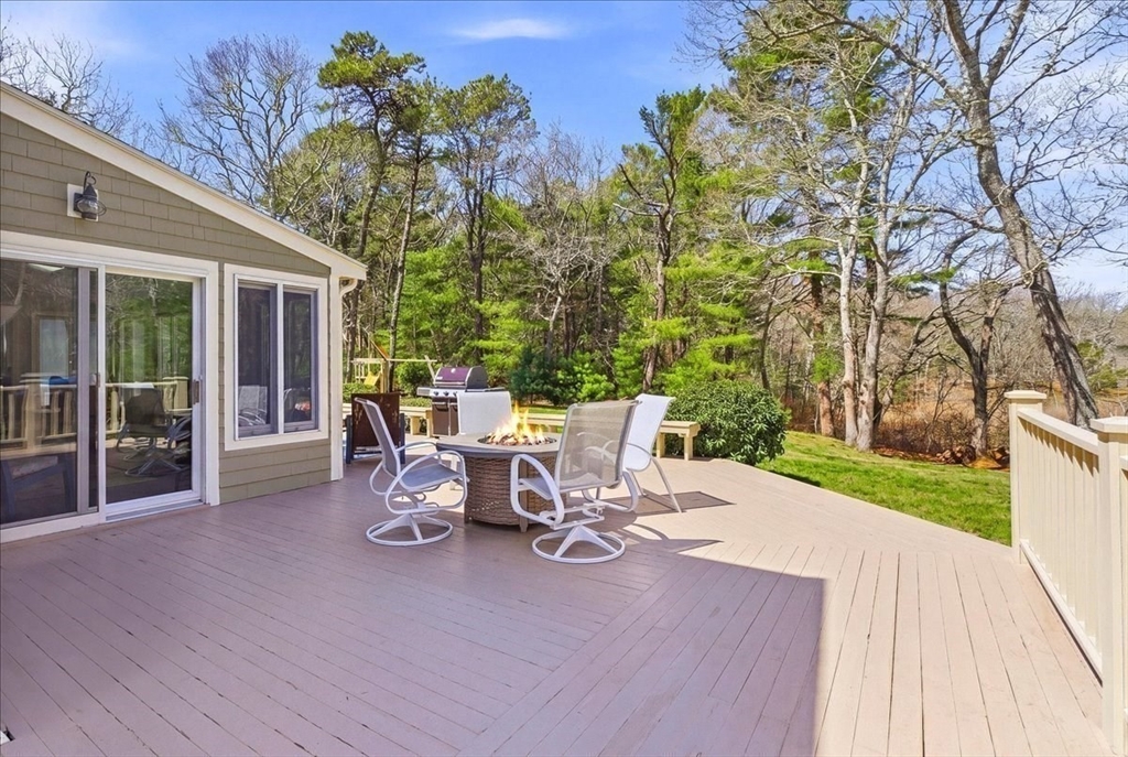 12 Salt Marsh Lane Wareham, MA 02571 - Photo 29 of 41 a view of a patio with table and chairs and potted plants with wooden floor and fence