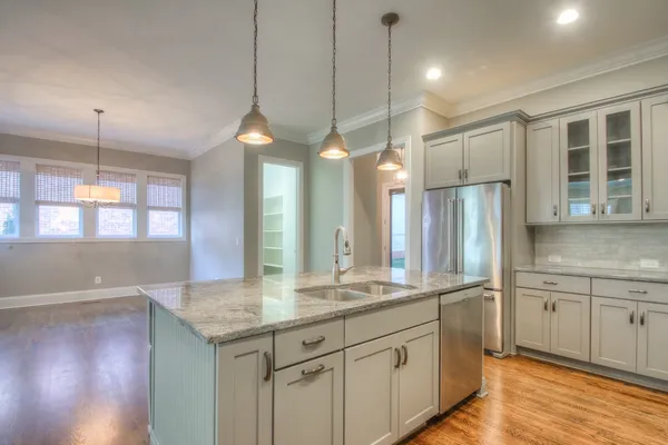 a kitchen with granite countertop a sink a counter space appliances and cabinets