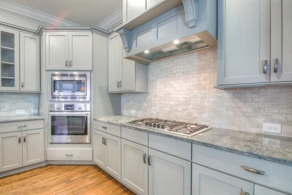 a kitchen with stainless steel appliances granite countertop a stove and cabinets
