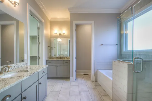 a bathroom with a granite countertop sink mirror and a bathtub