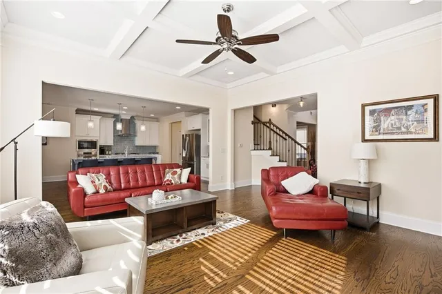 a living room with furniture ceiling fan and a large window