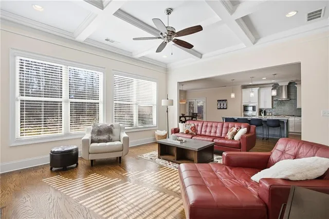 a open kitchen with granite countertop a stove a sink a dining table and chairs with wooden floor