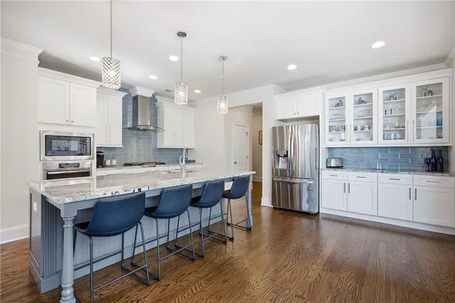 a kitchen with stainless steel appliances granite countertop a kitchen island a stove a cabinets a sink and a island