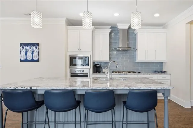 a large kitchen with stainless steel appliances kitchen island granite countertop a table chairs in it and a wooden floors