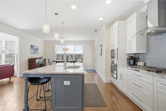a kitchen with stainless steel appliances granite countertop a sink a stove and cabinets