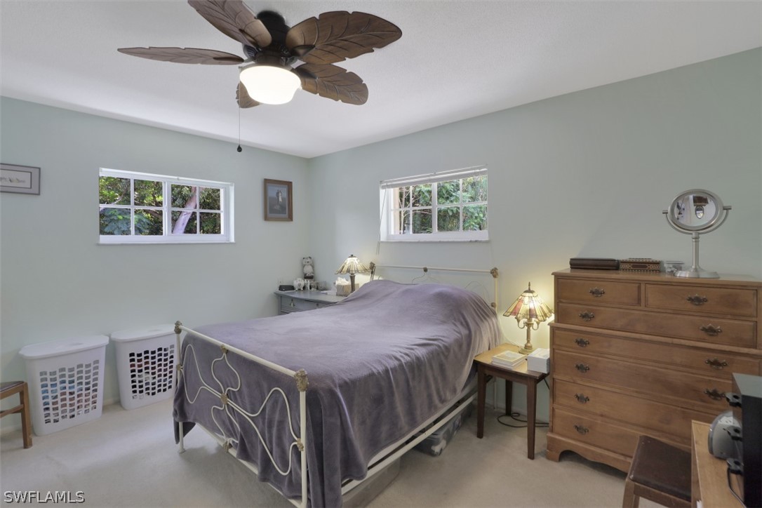 5807 Tarpon Road Bokeelia, FL 33922 - Photo 17 of 25 a bedroom with a bed and a chandelier