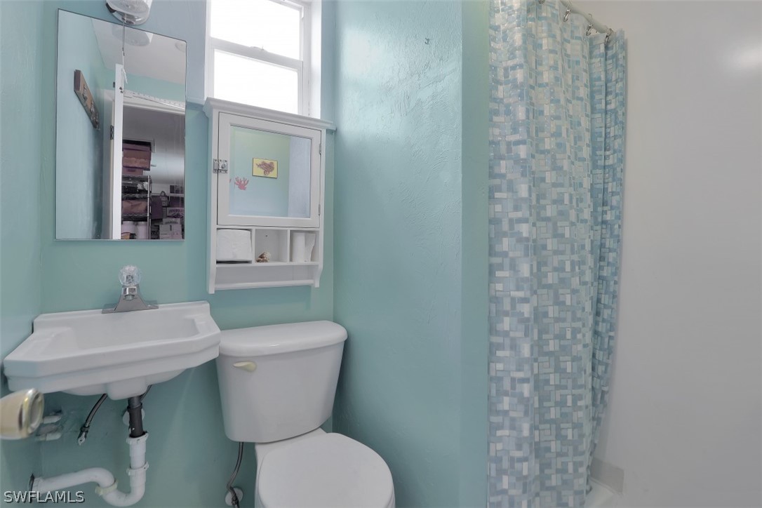 5807 Tarpon Road Bokeelia, FL 33922 - Photo 21 of 25 a bathroom with a sink a toilet and a mirror