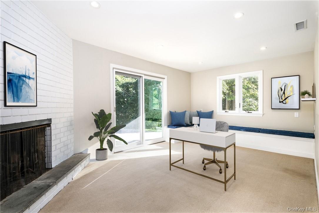 4 Parkfield Road Scarsdale, NY 10583 - Photo 23 of 33 Large study in lower level with fireplace and sliding doors to the yard - the perfect home office! (Digitally staged)