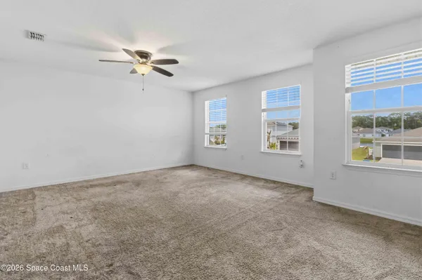 a view of a room with windows and ceiling fan