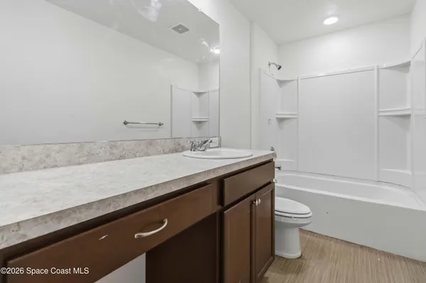 a bathroom with a granite countertop sink a toilet and bathtub