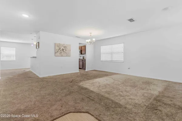 an empty room with windows and cabinet