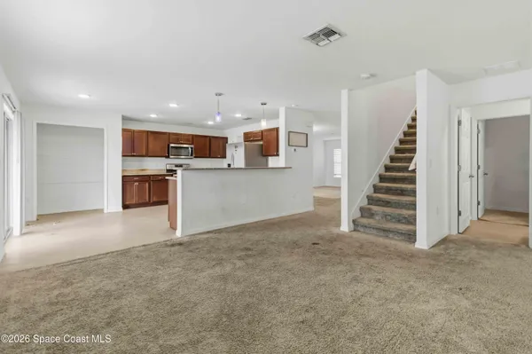 a view of a kitchen with a sink wooden cabinets and a kitchen
