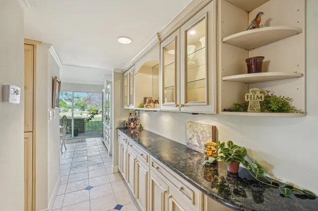 a large white kitchen with a large window and a potted plant