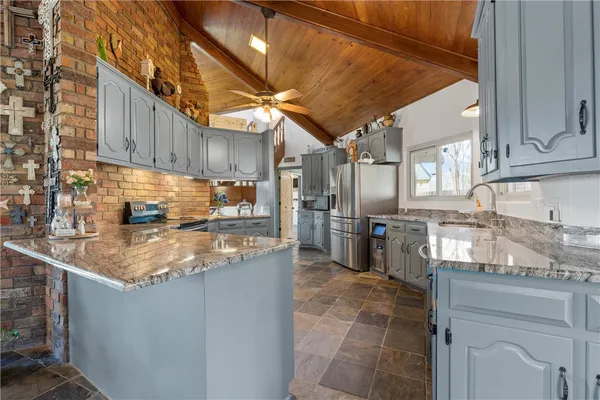 a kitchen with stainless steel appliances granite countertop a sink stove and cabinets