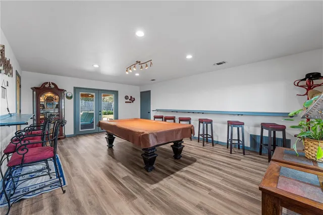a spacious bedroom with a bed a table and chair with the wooden floor