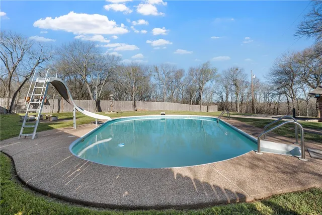 a view of a swimming pool with a yard