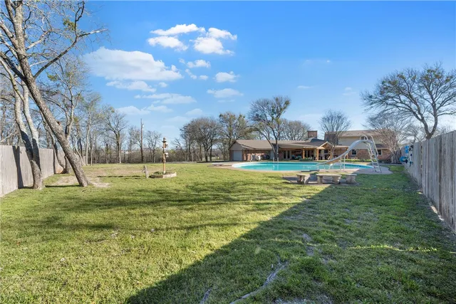 a view of swimming pool with a yard