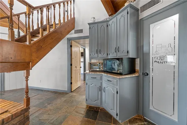 a kitchen with stainless steel appliances granite countertop a refrigerator a stove and white cabinets with wooden floor