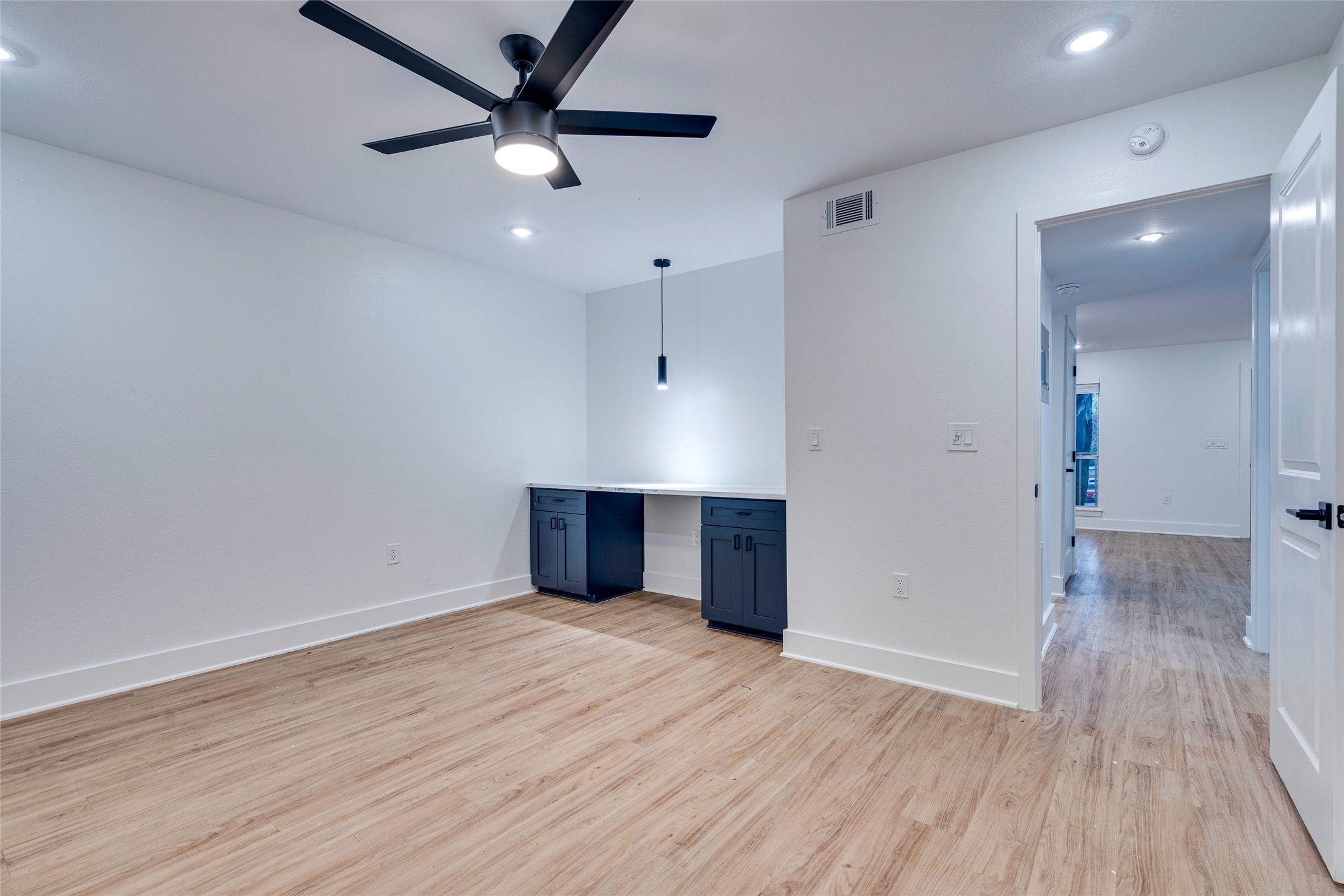 205 East 45th Street, Unit 202 Austin, TX 78701 - Photo 19 of 29 a view of an empty room with wooden floor and a ceiling fan