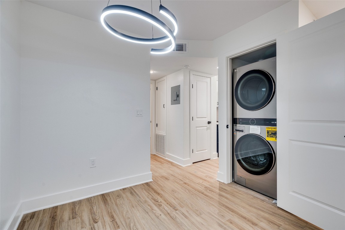 202 East 45th Street, Unit 202 Austin, TX 78751 - Photo 23 of 29 Laundry area featuring light wood-type flooring, stacked washer / drying machine, and electric panel