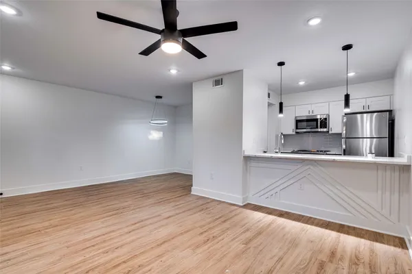 a view of kitchen with stainless steel appliances refrigerator stove microwave and cabinets