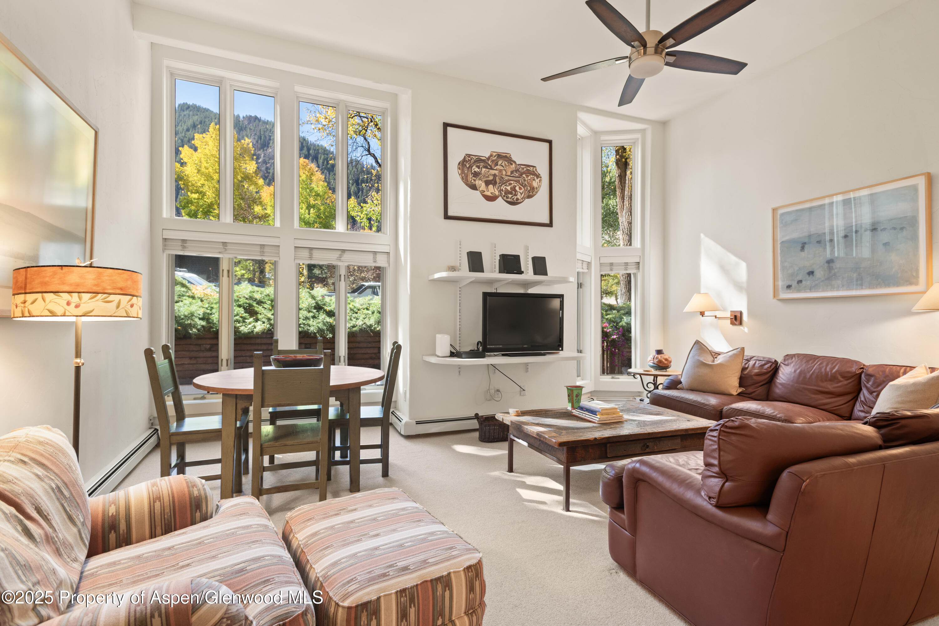 a living room with furniture a flat screen tv and a window