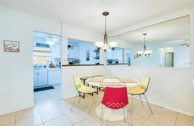a view of a dining room and livingroom with furniture wooden floor a rug a chandelier