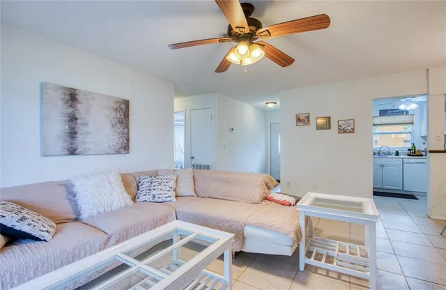 a living room with furniture and a view of kitchen