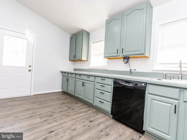 a kitchen with a sink cabinets and a wooden floor