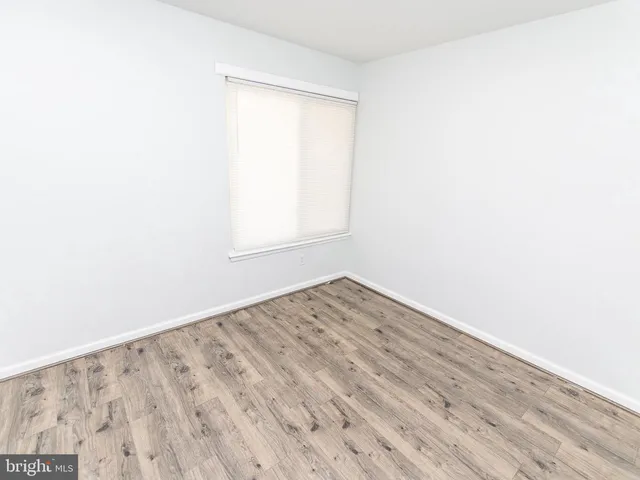 an empty room with wooden floor and a window