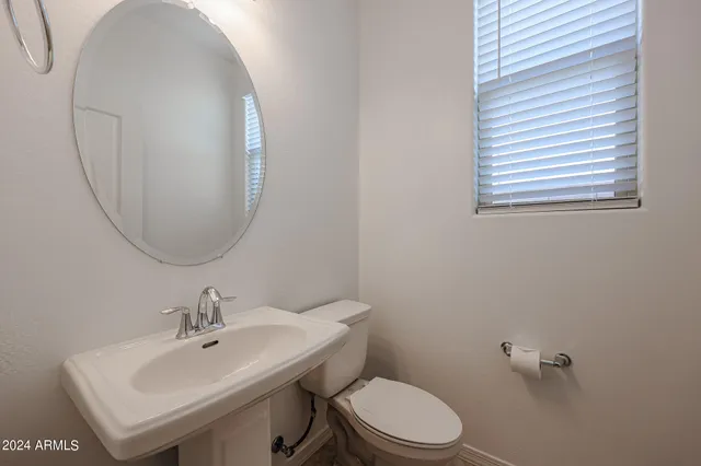 a bathroom with a sink a mirror and a toilet