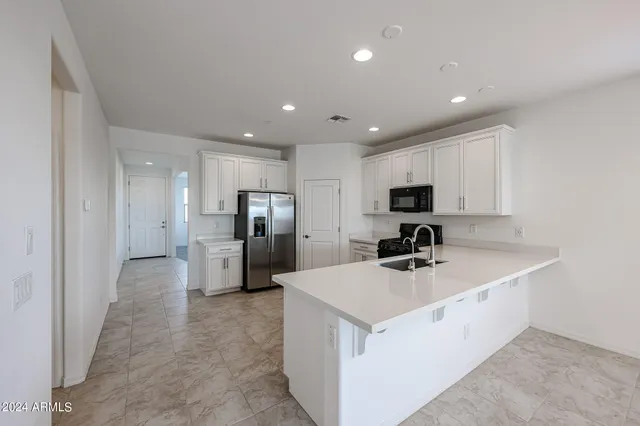a kitchen with a sink stainless steel appliances and white cabinets
