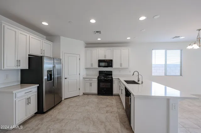 a kitchen with refrigerator a sink and cabinets