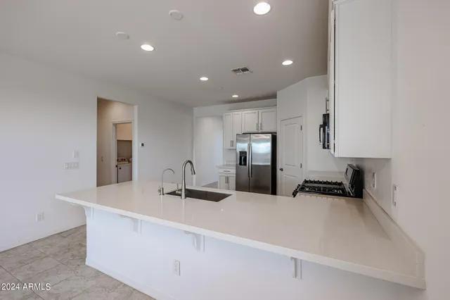 a kitchen with granite countertop a sink and a refrigerator
