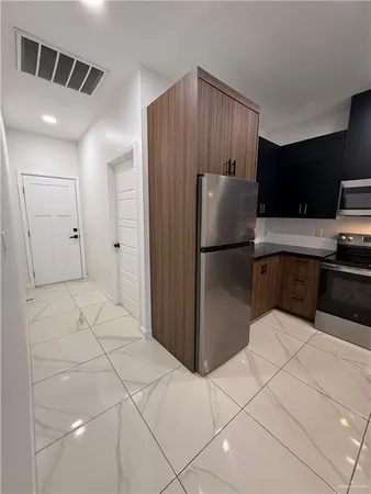 a kitchen with stainless steel appliances a refrigerator and cabinets
