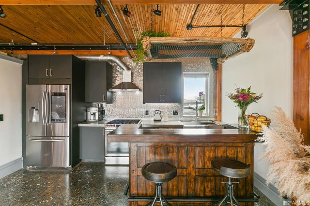 a kitchen with stainless steel appliances granite countertop a sink and a refrigerator