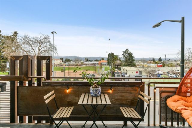 a view of a balcony with chairs and wooden floor