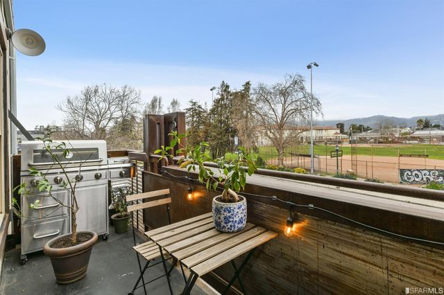 a view of a balcony with chairs and a rug