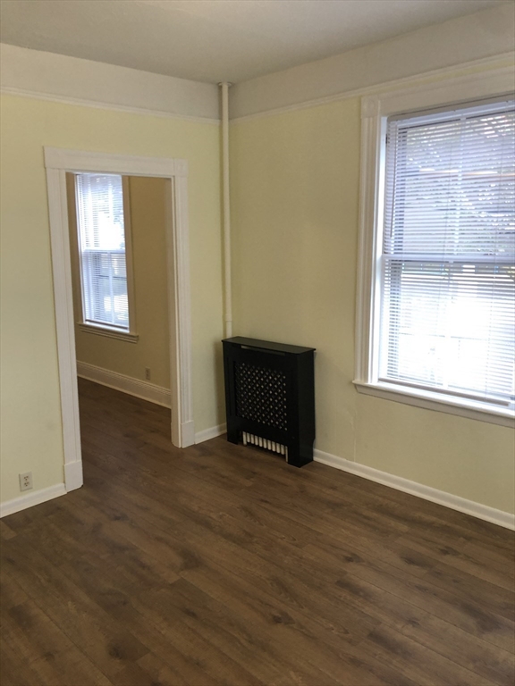 6 Rowley Street, Unit 1R Boston, MA 02122 - Photo 2 of 9 a view of an empty room with wooden floor and a window